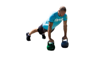 Man in a blue shirt kneeling and holding two kettlebells (green and blue) for a row exercise.